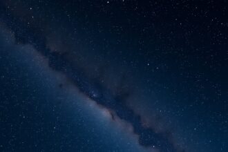 Csillagok és galaxis a sötét égen, csillagászat témában.