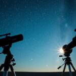 Két távcső az éjszakai ég alatt, csillagokkal a háttérben.