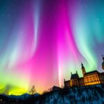 Színes sarki fény egy gyönyörű épület felett.