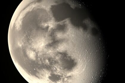 A Hold árnyékos oldala, éjszakai fényekkel és kráterekkel.