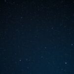 Férfiak és nők binokuláris csillagászattal az éjszakai égen.