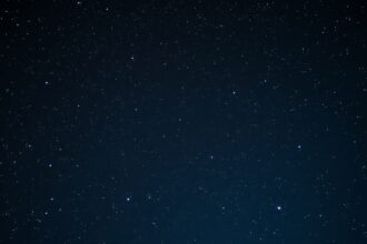 Férfiak és nők binokuláris csillagászattal az éjszakai égen.