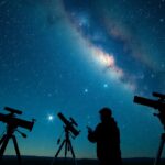 Csillagász távcsővel a Szűz csillagkép alatt, galaxisokkal