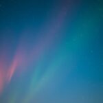 Színes éjszakai égbolt csillagokkal és fénycsóvákkal júniusban.