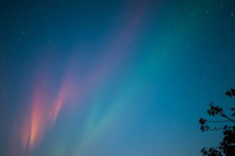 Színes éjszakai égbolt csillagokkal és fénycsóvákkal júniusban.