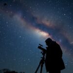 Csillagokat néző amatőr csillagász a teleszkóp mögött