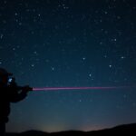 Lézermutató használata csillagok mutatására az éjszakai égbolton.