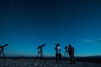 Csillagászok távcsövekkel a csillagos éjszakában
