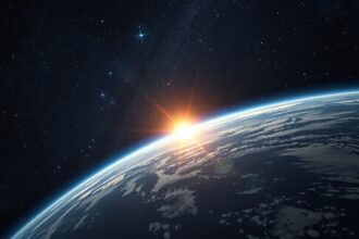 A Föld napfelkeltéje az űrből nézve, a csillagok között.