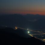 Fénygyengülés jelensége a távoli hegyek és városi fények között