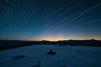 Sarkkörüli csillagok az éjszakai égbolton hófedte tájon