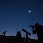 Két amatőr csillagász távcsővel nézi az ég csillagait éjszaka